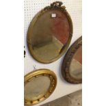A circa 1900 gilt wood framed oval bevelled wall mirror, with floral crested surmount, 60 x 45cm,