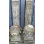 A pair of reconstituted stone fluted garden columns, each with cylindrical sphere surmounts,