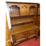 An early 20th century oak dresser, with two-tier open plate rack and single central upper cupboard