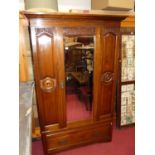 An Edwardian walnut and floral relief carved single bevelled mirror door wardrobe, having single