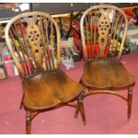 A set of four elm and beech wheelback kitchen chairs having dished seats, and on crinoline