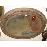 A 19th century floral relief carved oak oval bevelled wall mirror, 78 x 91cm