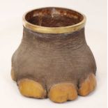 A decorative elephant foot wastepaper bin, with brass rim and typical hollowed-out interior, h.34.