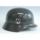 A reproduction German M 1935 steel helmet with Waffen SS and swastika decals, having a leather liner