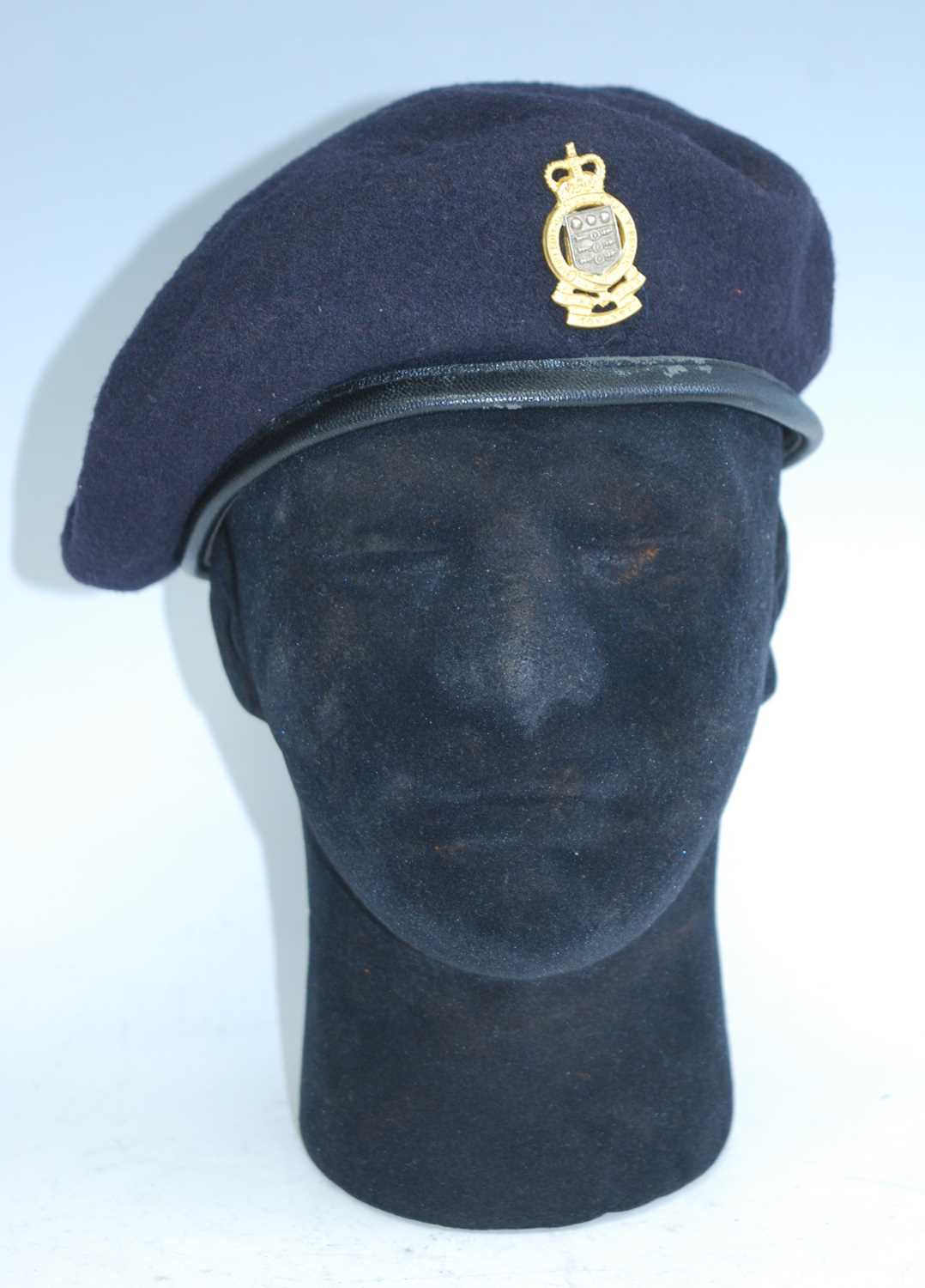 A blue woollen beret with badge for the Army Ordnance Corps, together with a United Nations beret