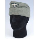 A replica German Army Overseas side cap, in black with silver piping, together with one other