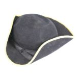 A Chelsea Pensioners tricorn hat, in black felt with silk band, the folded sides with yellow trim,