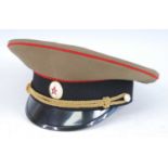 A Russian Officer's peaked cap, in green with red piping, together with a reproduction German