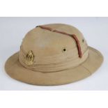 A WW II Foreign Service cloth covered pith helmet with GR VI Military Police badge, having a silk