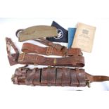 A tin trunk and contents to include a WW I Sam Browne belt with cross strap, leather sword frog,