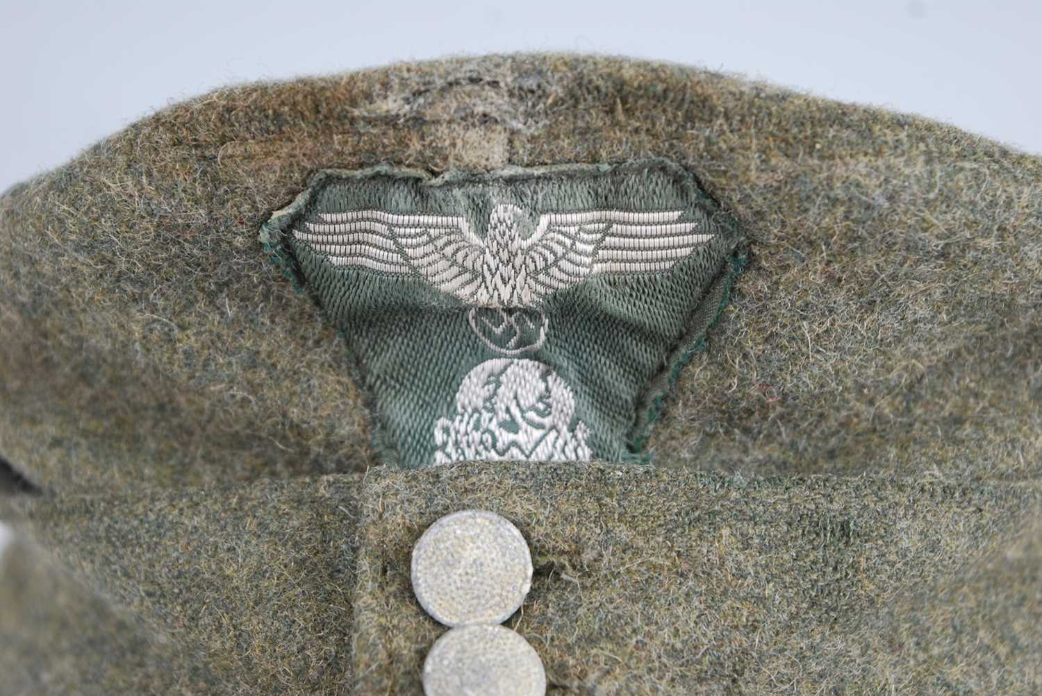 A German M43 SS Field cap, in green wool with stitched badge, the interior stamped SS-BW, dated - Image 2 of 5