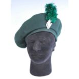 A Royal Irish Regiment beret with badge and feather plume, having a quilted interior, together