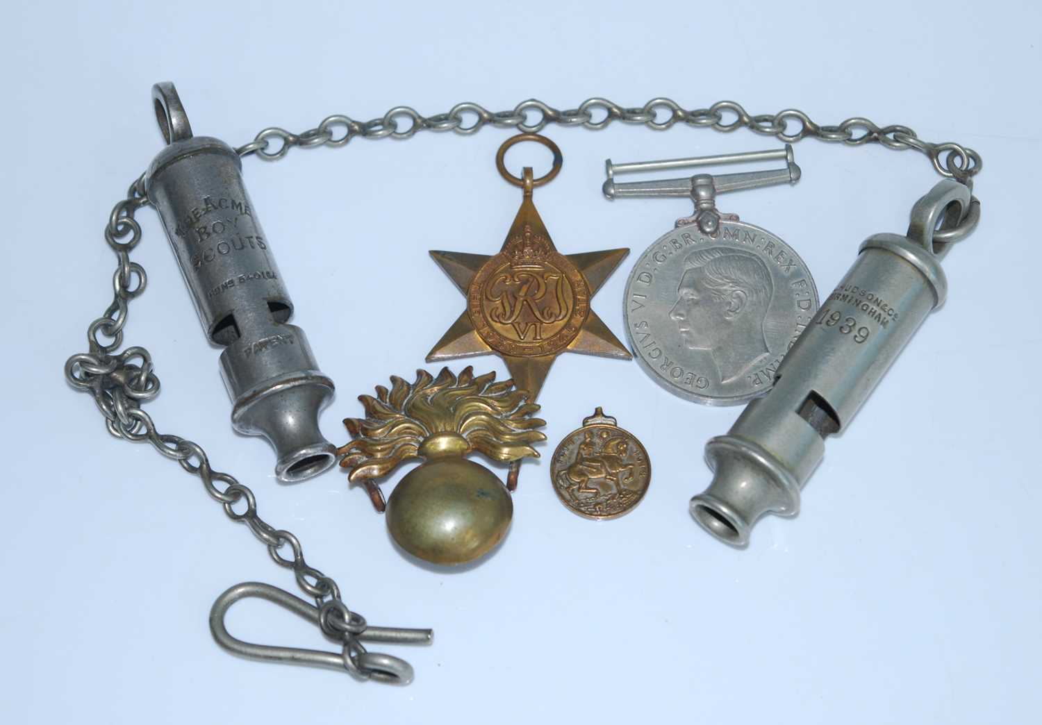 A WW II 1939-1945 Star and Defence medal, together with an artillery flaming grenade badge, a