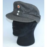 A post WW II German M43 grey woolen field cap, together with one other leather cap. (2)