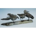 Mike Wood, (b.1943), a hand carved group of three Dunlin's mounted on a wooden base, signed and