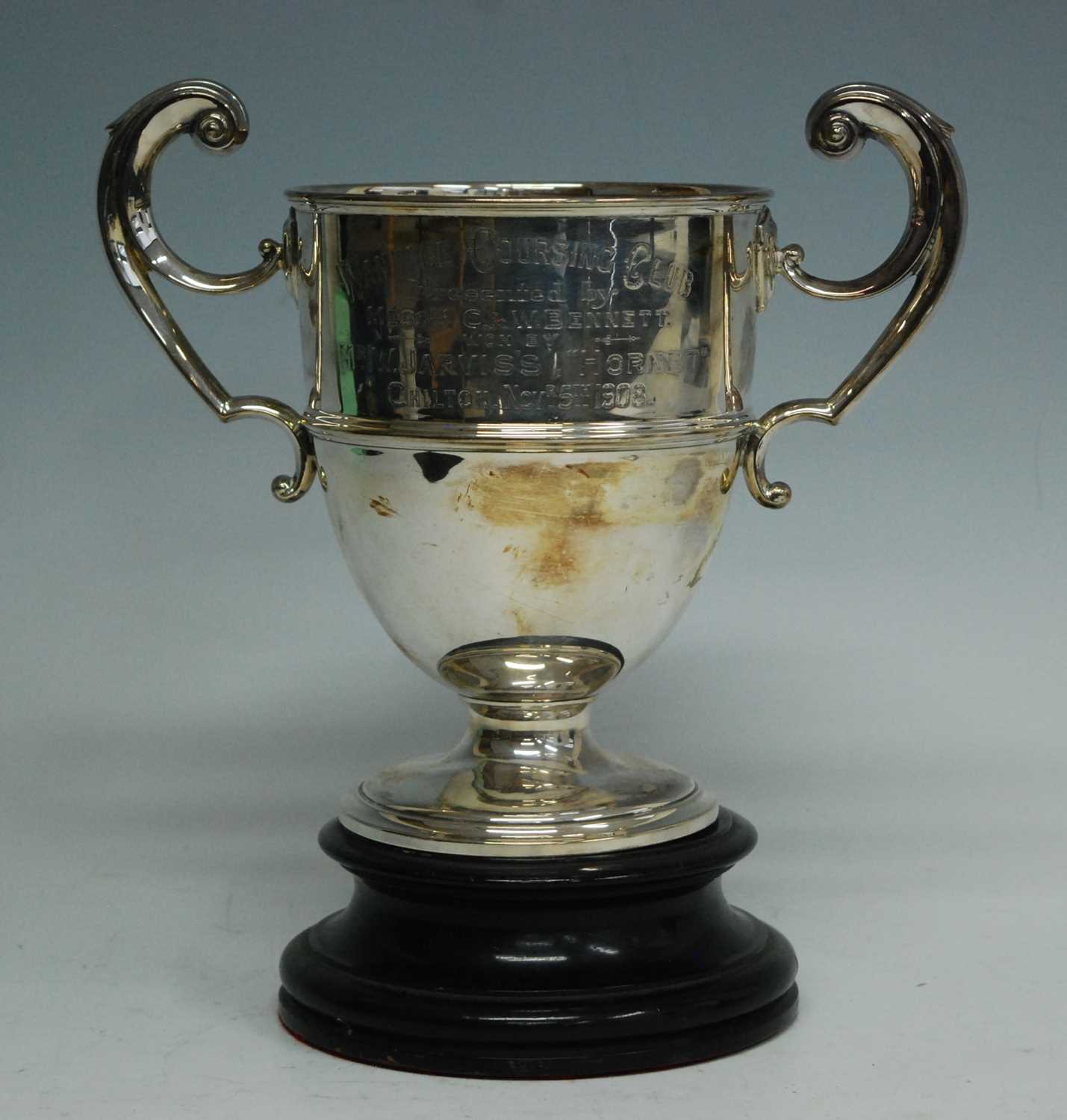 An Edwardian silver trophy cup, the body with a central band and twin c-scroll handles, engraved "