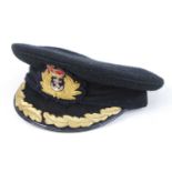 A WW II Royal Navy Captains visor cap, in black felt with bullion badge and gold braided peak.