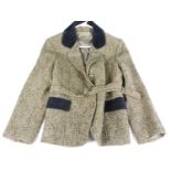 A ladies hunting jacket in green and brown chequered wool with black felt trim and green buttons,
