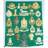 A collection of British Army cap badges and insignia, to include The Cambridgeshire Regiment, The