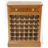 A walnut and burr walnut wine rack, having a crossbanded top and single frieze drawer above 36-