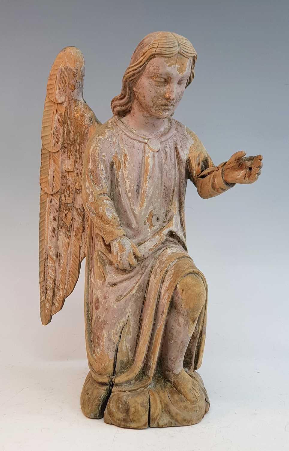 An 18th century carved pine figure of an angel, shown on one knee with arm outstretched, h.41cm Both