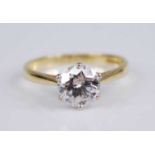 An 18ct yellow and white gold diamond solitaire ring, featuring a round brilliant cut diamond in a