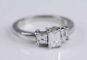 A platinum diamond three stone ring, featuring a centre emerald cut with an asscher cut diamond on