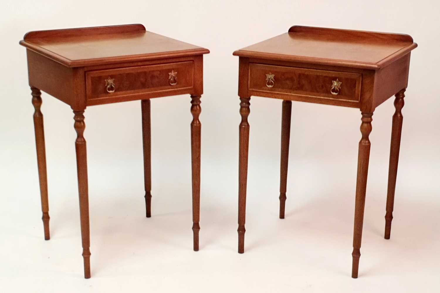 A pair of figured walnut and walnut lamp tables, each having four-quarter veneered cross and feather