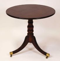 A Regency plum pudding mahogany circular tilt-top pedestal tripod table, raised on ring turned