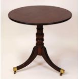 A Regency plum pudding mahogany circular tilt-top pedestal tripod table, raised on ring turned