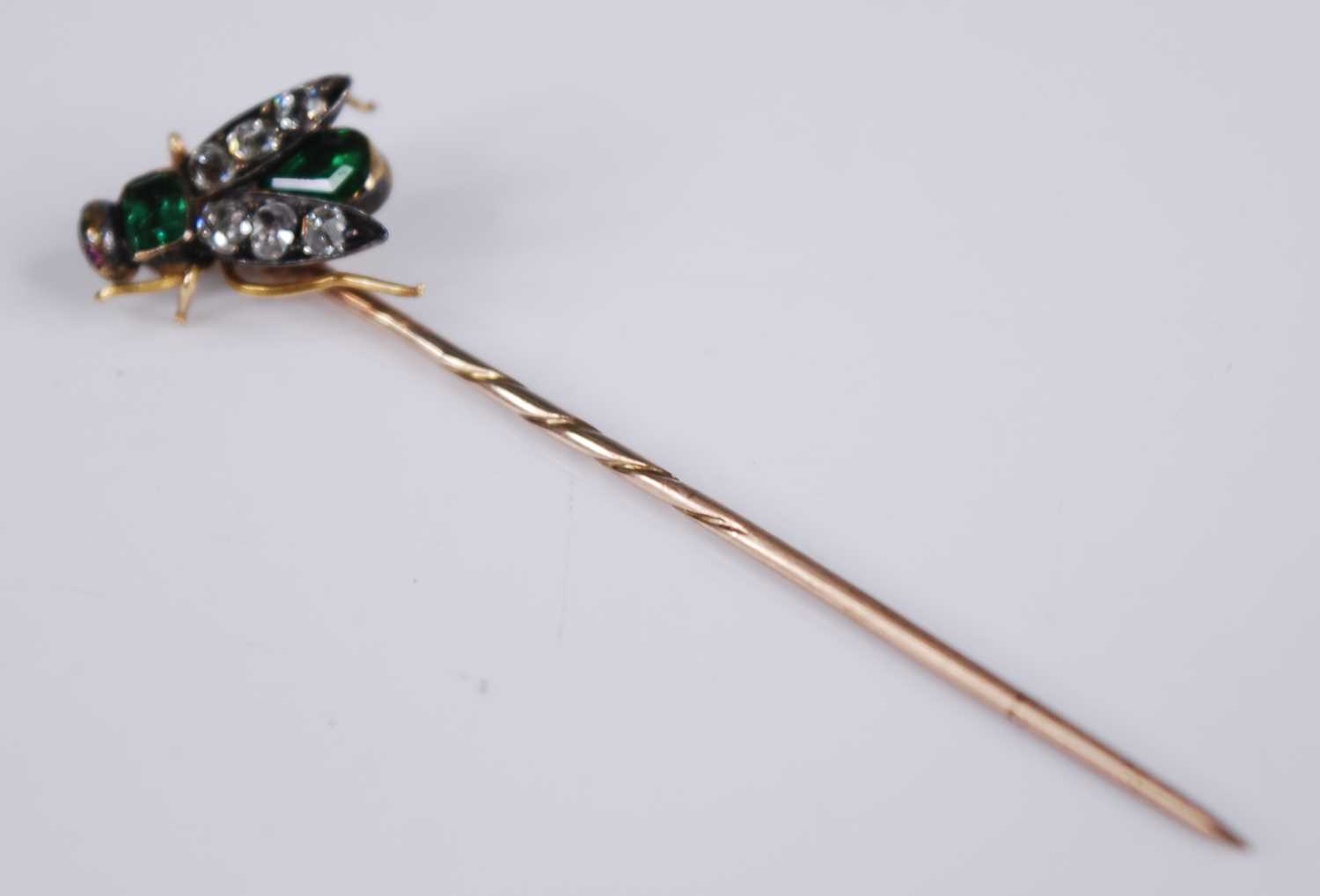 A yellow metal diamond, emerald and ruby stick pin in the form of a winged inset, set with a 3.9 x - Image 2 of 7