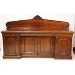 An early Victorian plum-pudding mahogany ledgeback sideboard, having floral carved detail, egg and