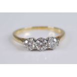 An 18ct yellow and white gold diamond three stone ring, featuring three graduated round brilliant