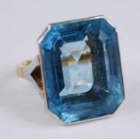 A yellow and white metal aquamarine single stone ring, featuring an emerald cut aquamarine in a