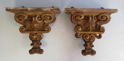 A pair of early 19th century gilt wood wall brackets, each carved with voluted and foliate