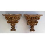 A pair of early 19th century gilt wood wall brackets, each carved with voluted and foliate