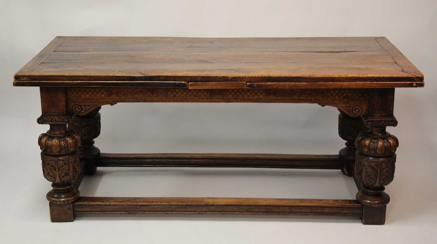 An antique oak drawleaf refectory table in the Elizabethan style, the three-plank top with cleated