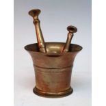 An 18th century bronze mortar, of plain tapered form, h.11cm, together with two bronze pestles