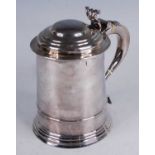 A George I silver lidded tankard, of flaring cylindrical form, the domed cover with scroll