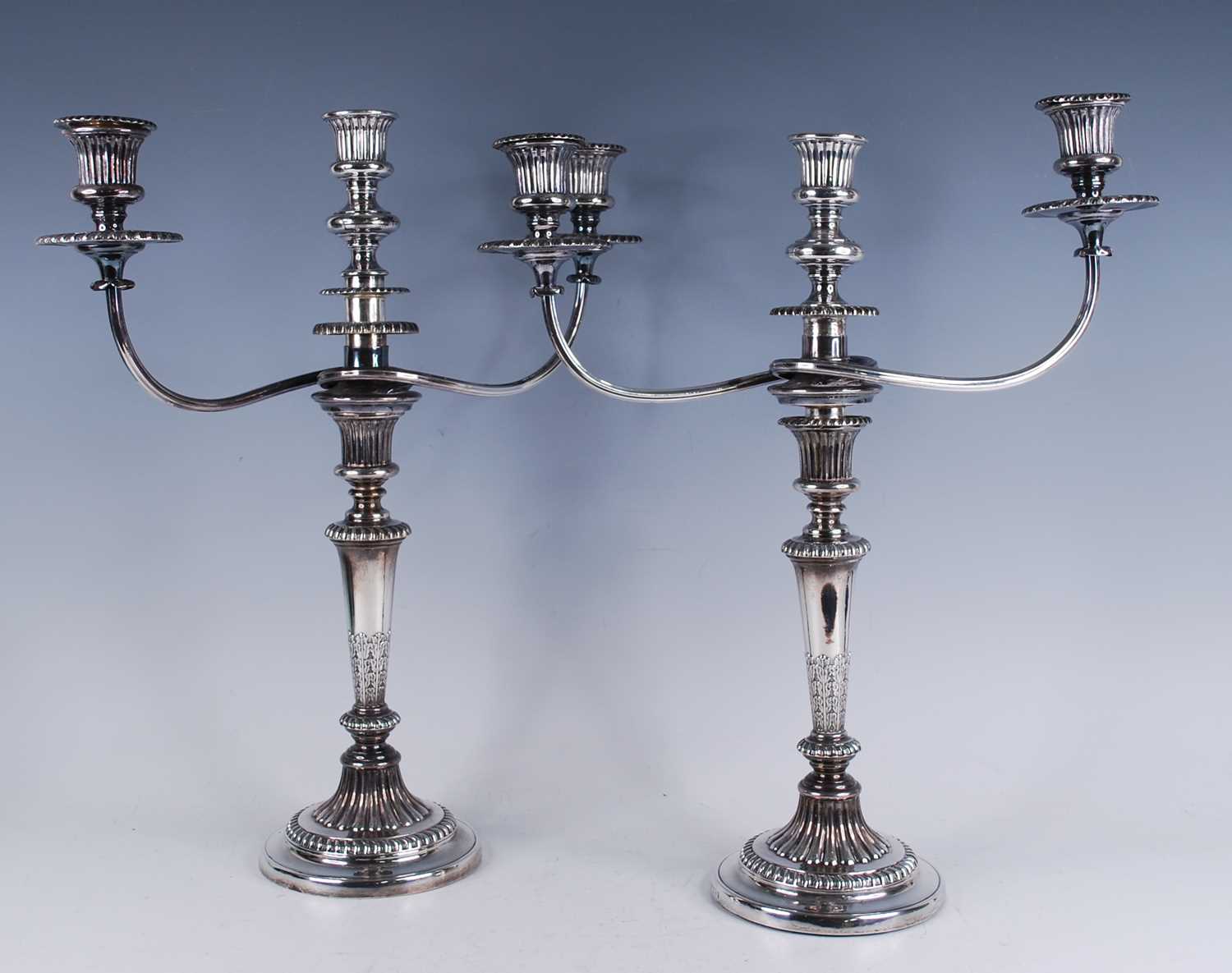 A pair of George III silver candlesticks, with matching plated three-light candelabra over, the