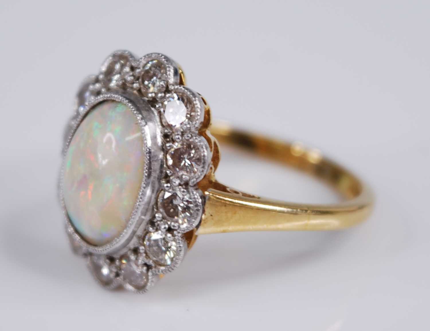 An 18ct gold and platinum, opal and diamond set cluster ring, arranged as a central opal cabochon - Image 2 of 3