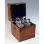 A Victorian figured walnut decanter box, the lid with monogrammed cartouche lifting to reveal four