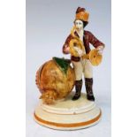 A 19th century continental cream glazed earthenware moneybox, in the form of a man playing a horn