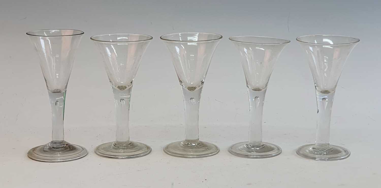A matched set of five 18th century style wine glasses, the drawn trumpet bowl above a teared stem
