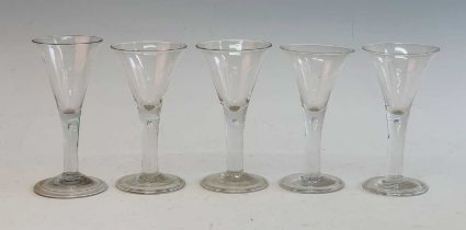 A matched set of five 18th century style wine glasses, the drawn trumpet bowl above a teared stem