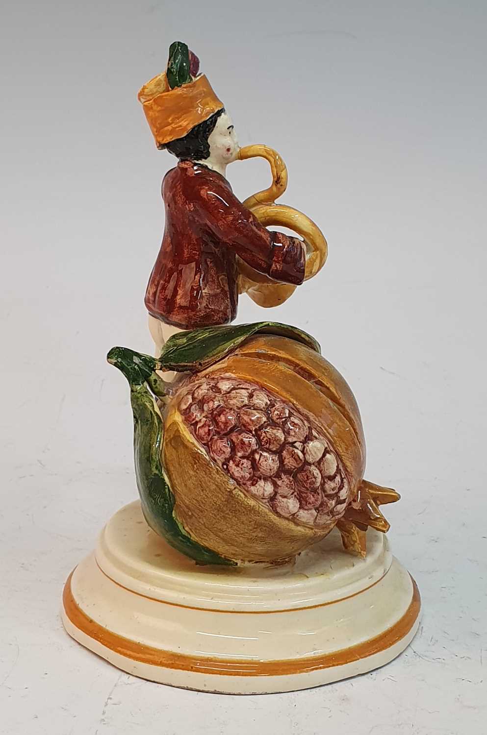 A 19th century continental cream glazed earthenware moneybox, in the form of a man playing a horn - Image 2 of 5