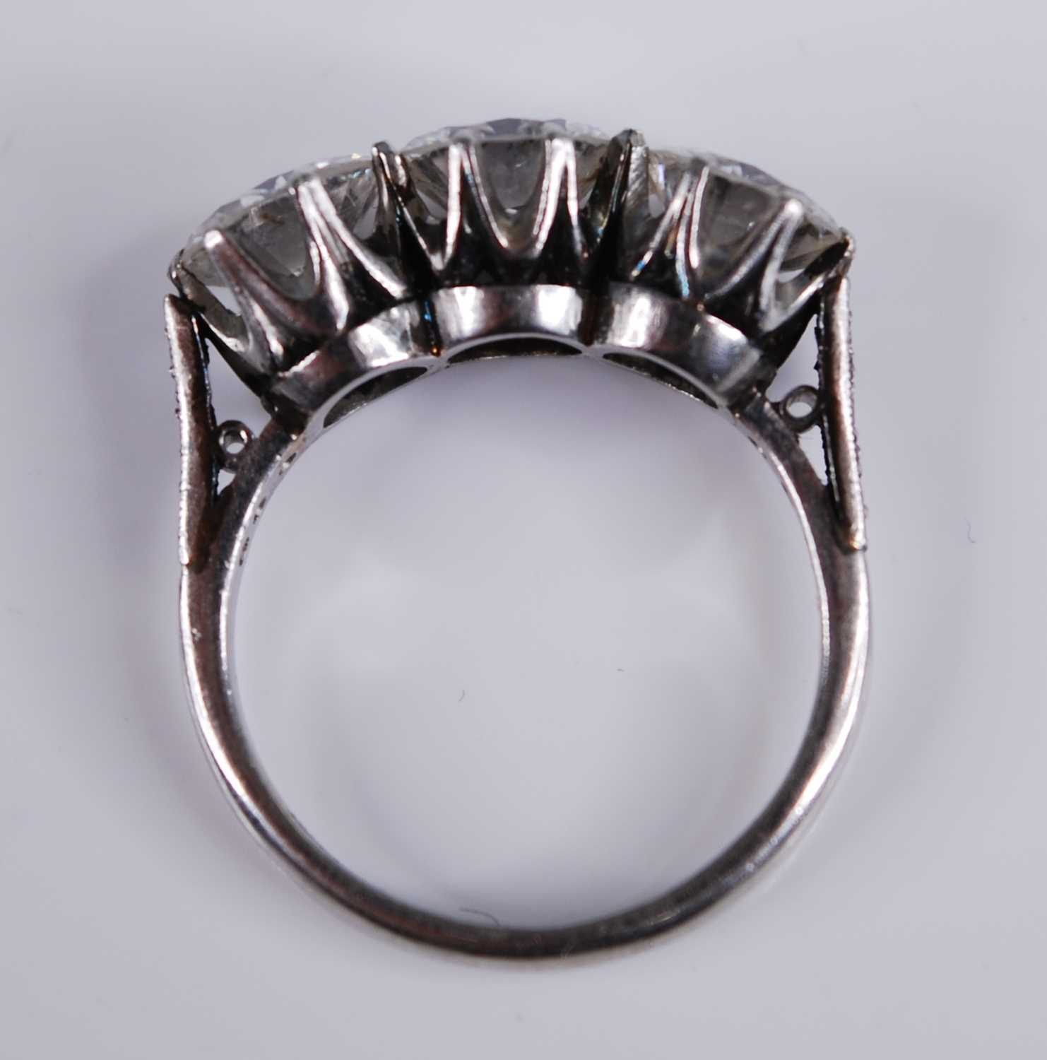 A white metal diamond three stone ring, comprising three round brilliant cut diamonds in claw - Image 6 of 7