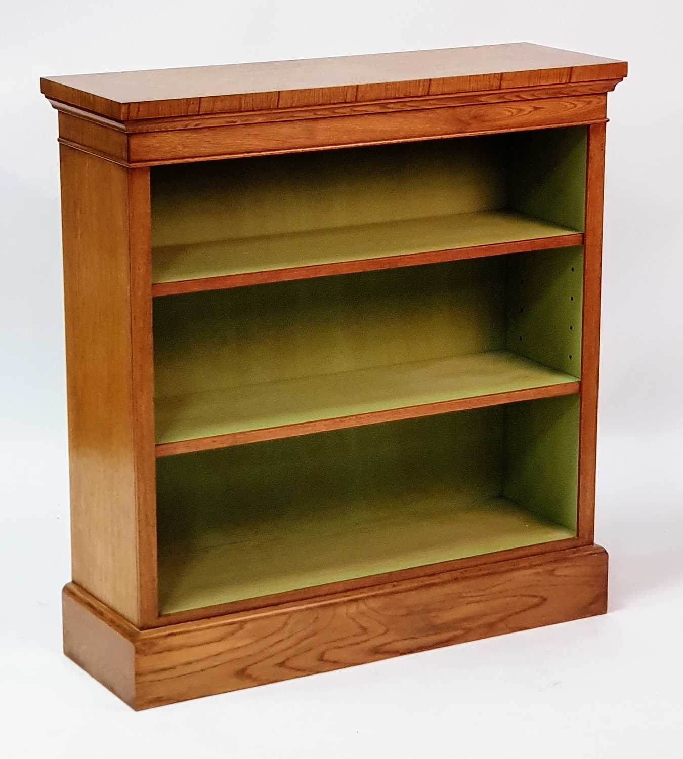 A Victorian style walnut and figured walnut open bookcase, having a cross and feather banded top