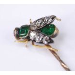 A yellow metal diamond, emerald and ruby stick pin in the form of a winged inset, set with a 3.9 x