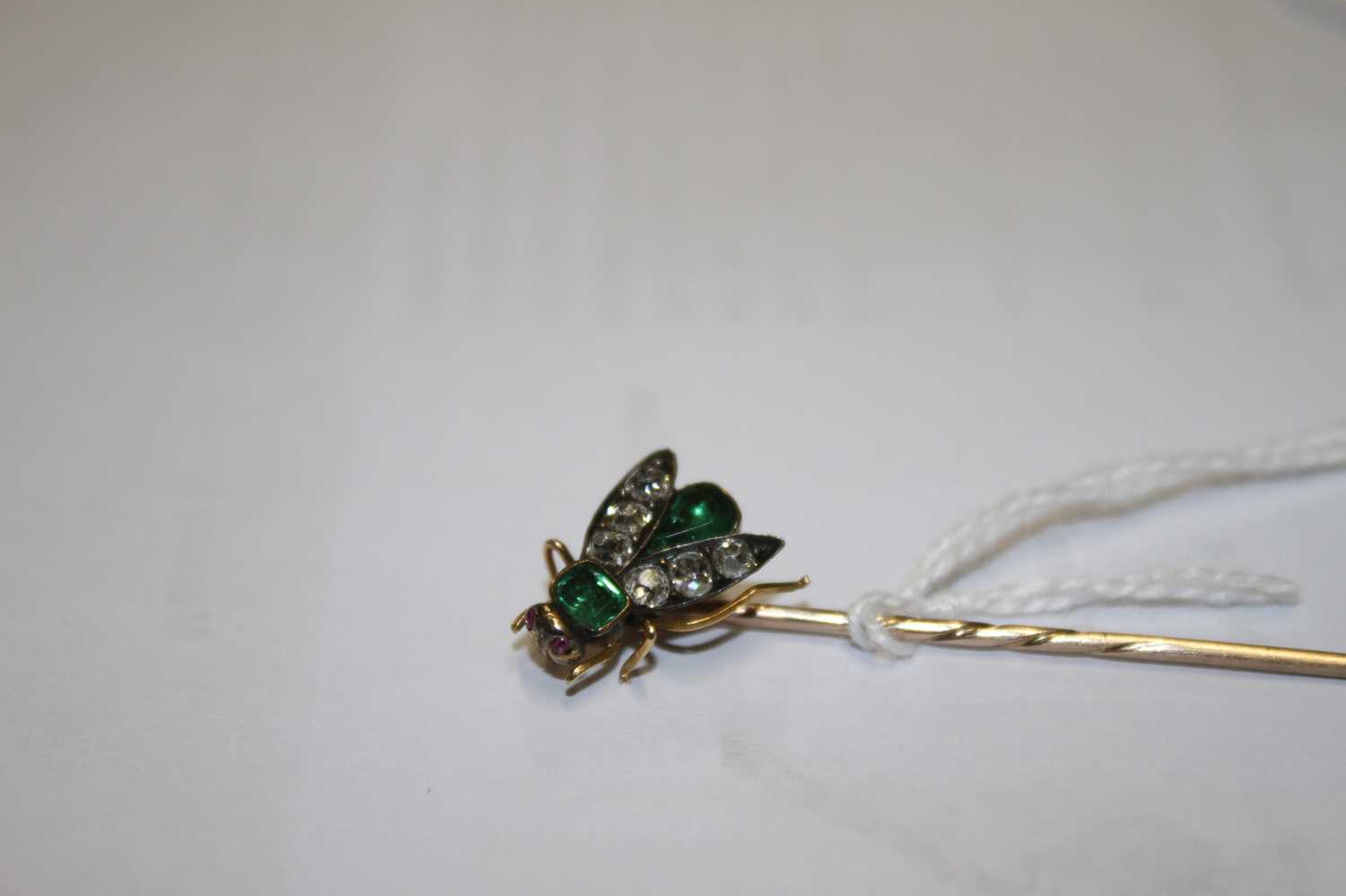 A yellow metal diamond, emerald and ruby stick pin in the form of a winged inset, set with a 3.9 x - Image 4 of 7